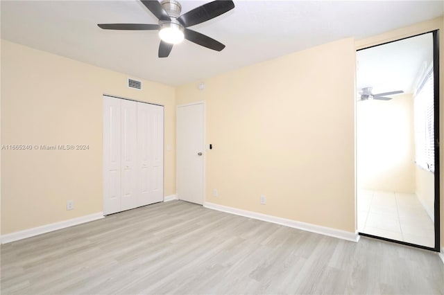 unfurnished bedroom featuring light hardwood / wood-style flooring, a closet, and ceiling fan