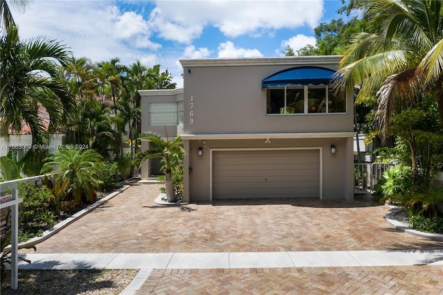 1769 Wa Kee Na Dr, Miami, FL 33133 - view of front of house featuring stucco siding, decorative driveway, and a garage