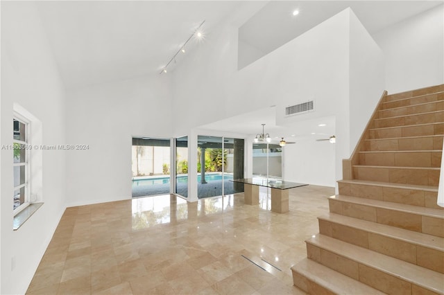 unfurnished living room with a high ceiling and track lighting