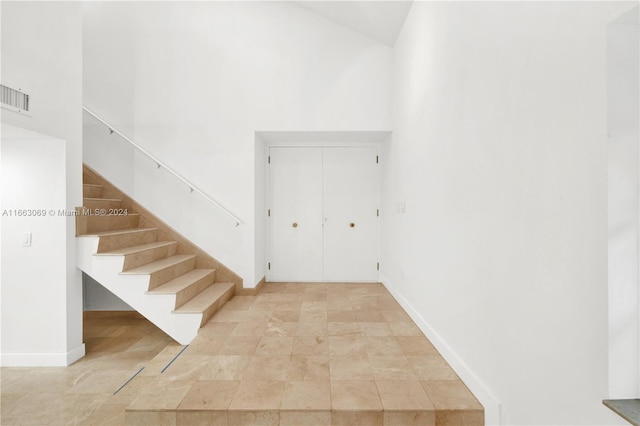 1769 Wa Kee Na Dr, Miami, FL 33133 - stairs with visible vents, a towering ceiling, and baseboards