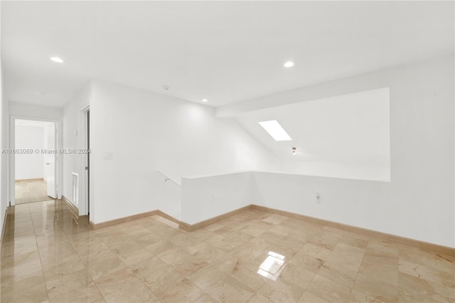 bonus room with vaulted ceiling with skylight