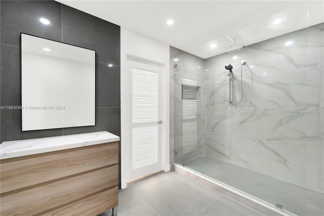 bathroom with walk in shower, vanity, and tile patterned flooring