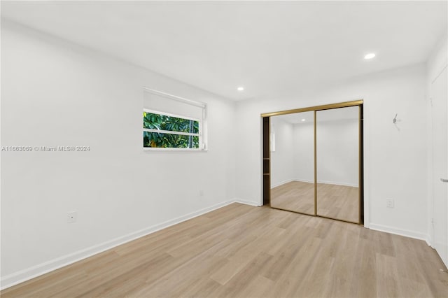 unfurnished bedroom featuring a closet and light hardwood / wood-style flooring