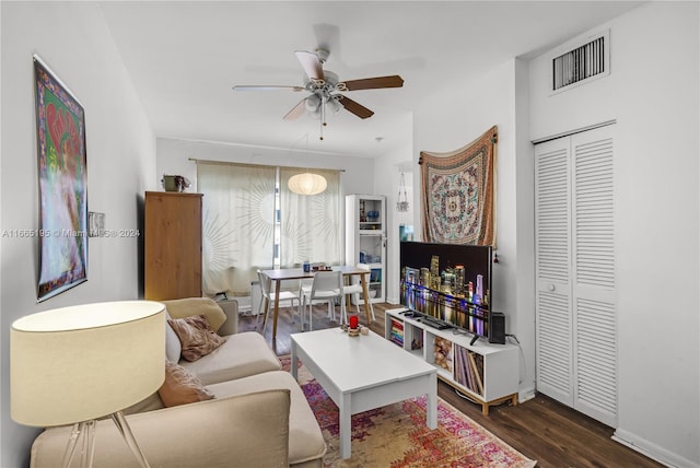 living room featuring ceiling fan and dark hardwood / wood-style floors