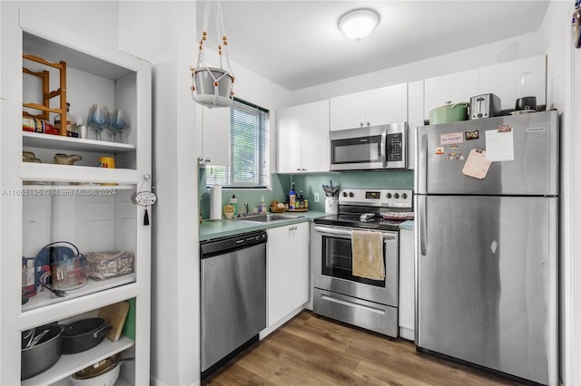 kitchen featuring stainless steel appliances, dark hardwood / wood-style floors, sink, and white cabinetry