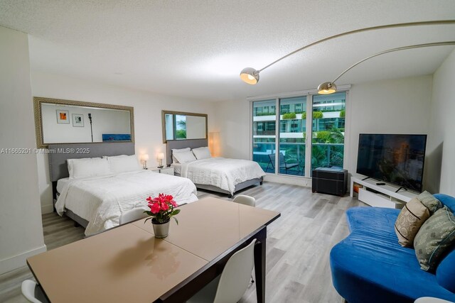 bedroom featuring light wood-type flooring and a textured ceiling