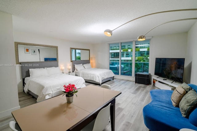 bedroom featuring a textured ceiling and light hardwood / wood-style flooring