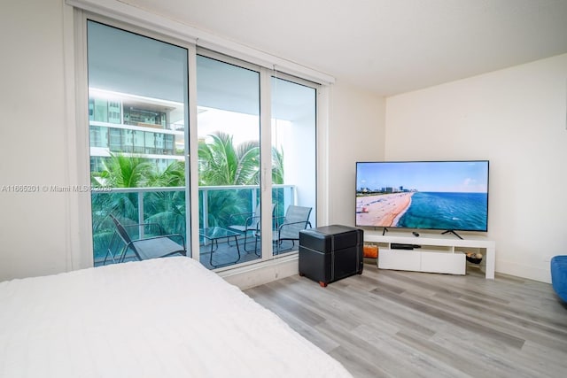 bedroom featuring a wall of windows and hardwood / wood-style floors