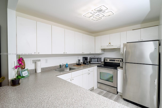 kitchen featuring light wood-type flooring, stainless steel appliances, sink, and white cabinets