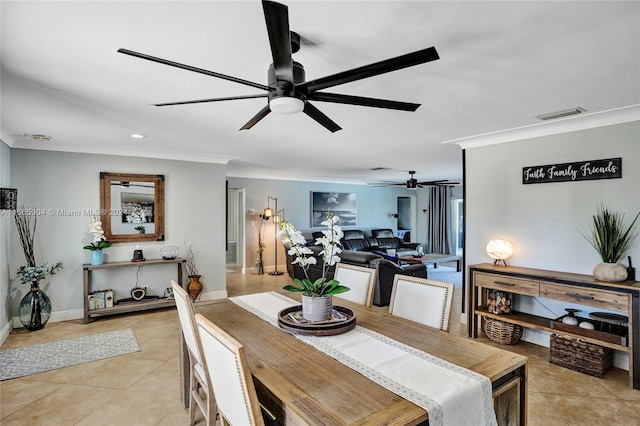 tiled dining space with ceiling fan and ornamental molding