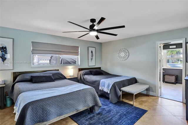 tiled bedroom featuring ceiling fan