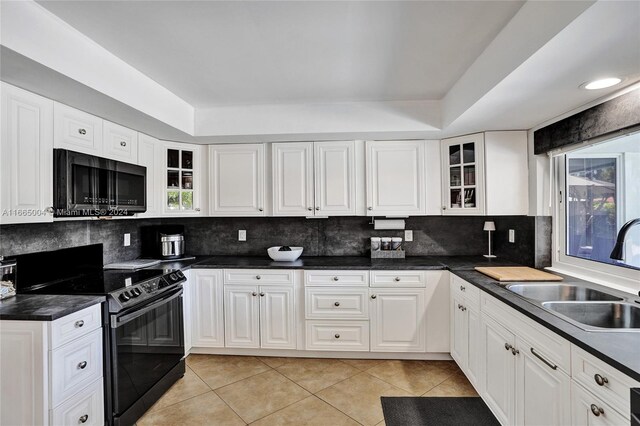 kitchen featuring tasteful backsplash, sink, white cabinets, black appliances, and light tile patterned floors