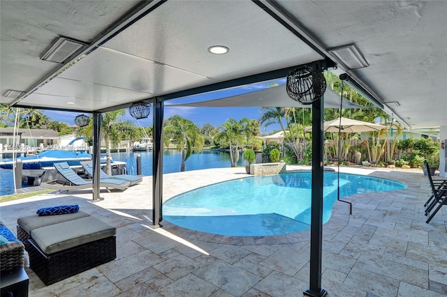 view of pool with a water view and a patio area