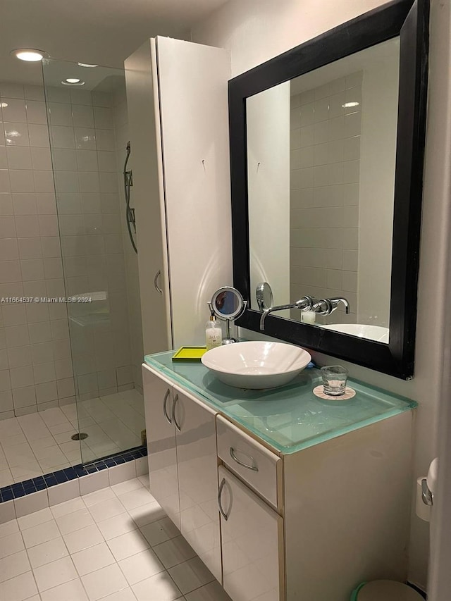 bathroom with vanity, tile patterned flooring, and a tile shower