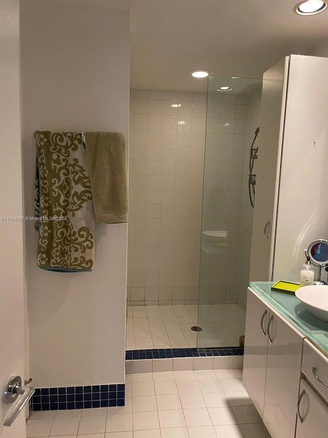 bathroom with tiled shower, vanity, and tile patterned floors