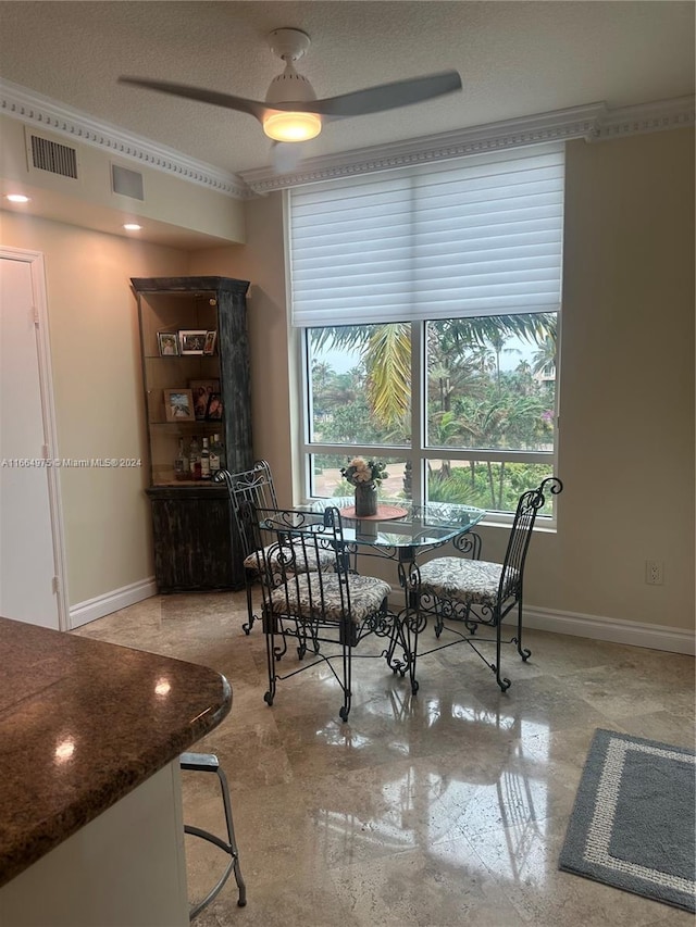 dining space featuring ceiling fan and a textured ceiling