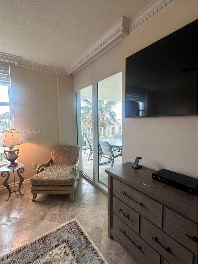 sitting room with a textured ceiling and ornamental molding