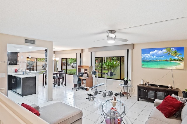 tiled living room featuring a textured ceiling, sink, and ceiling fan