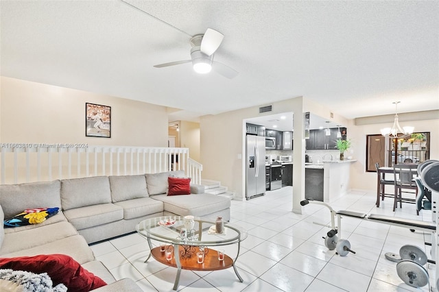 tiled living room with a textured ceiling, ceiling fan with notable chandelier, and sink