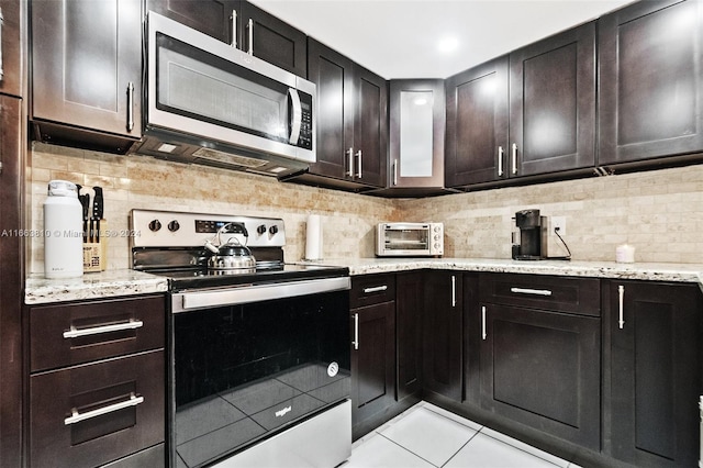 kitchen with dark brown cabinetry, appliances with stainless steel finishes, and light tile patterned floors