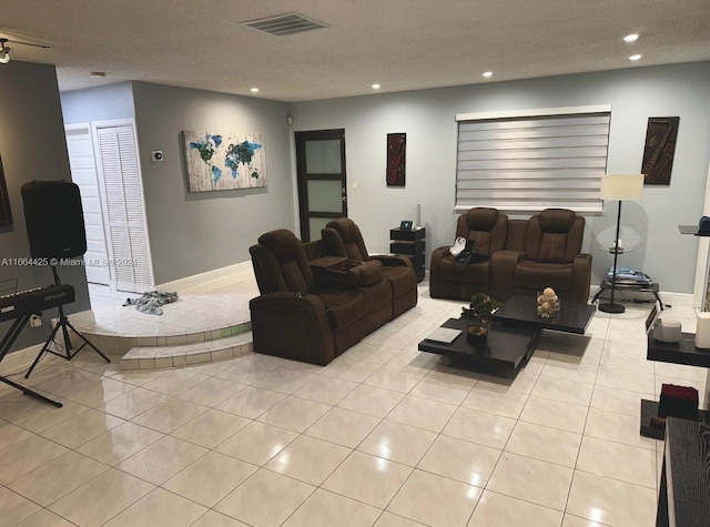 living room featuring a textured ceiling and light tile patterned floors