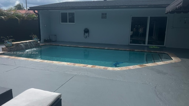 view of swimming pool featuring pool water feature and a patio