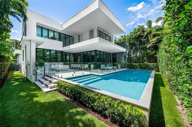 5327 N Bay Rd, Miami Beach, FL 33140 - rear view of property featuring a balcony, a yard, an outdoor pool, stucco siding, and a patio area
