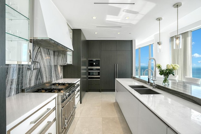 kitchen featuring backsplash, a sink, modern cabinets, premium range hood, and high end range