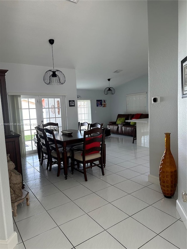 dining area with lofted ceiling and light tile patterned floors