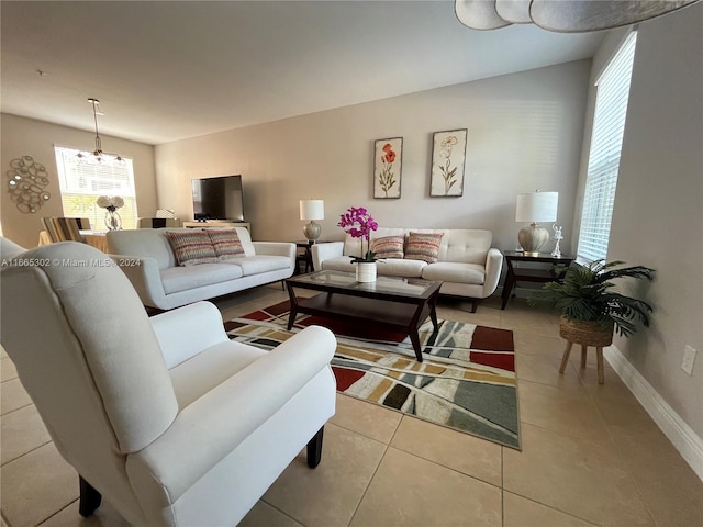 living room featuring a notable chandelier and light tile patterned flooring