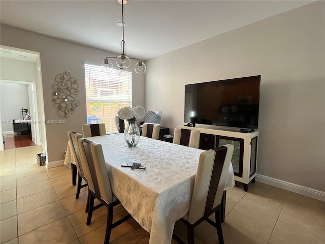 tiled dining room with a chandelier