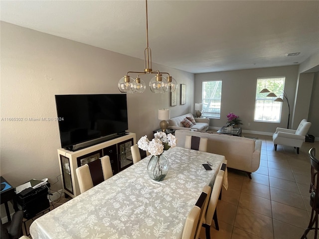 dining space with an inviting chandelier and tile patterned flooring