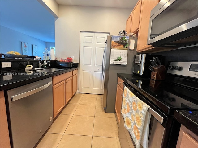 kitchen with appliances with stainless steel finishes, sink, and light tile patterned floors