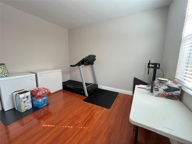 exercise room with wood-type flooring