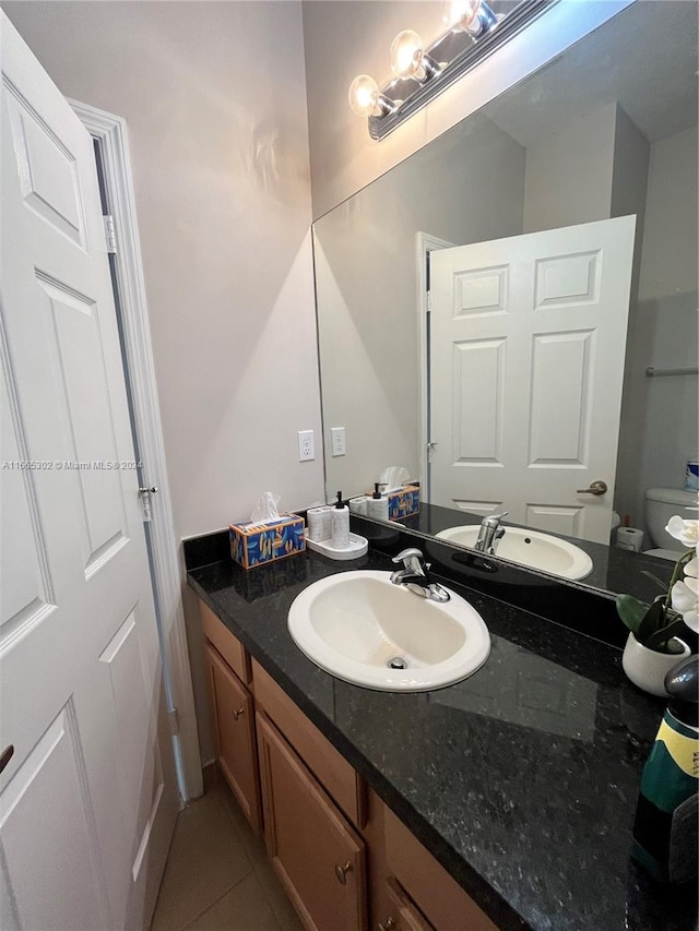 bathroom featuring tile patterned floors, vanity, and toilet