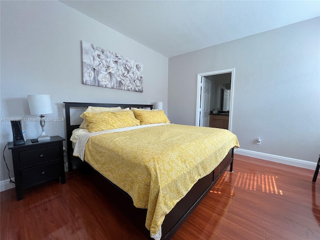 bedroom with dark hardwood / wood-style floors and ensuite bathroom