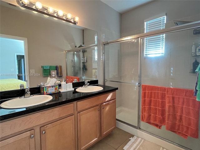 bathroom with walk in shower, tile patterned flooring, and vanity