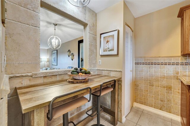 kitchen featuring sink, stainless steel dishwasher, light tile patterned floors, electric range oven, and light stone counters