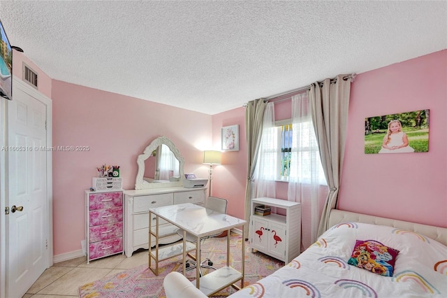 bedroom featuring light tile patterned floors, a textured ceiling, and visible vents