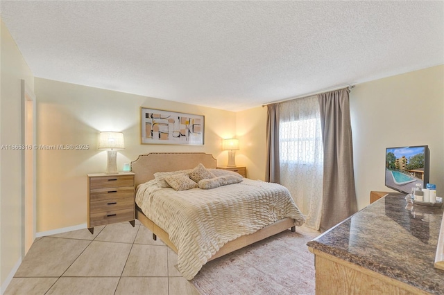 bedroom with light tile patterned floors and a textured ceiling