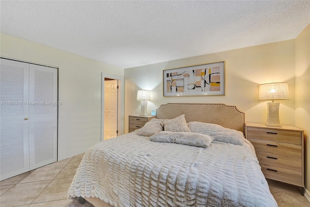 bedroom featuring a textured ceiling, a closet, and tile patterned floors