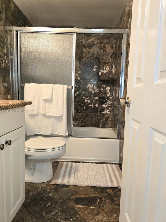 full bathroom with vanity, enclosed tub / shower combo, and toilet