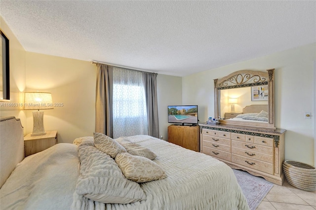 bedroom with a textured ceiling and light tile patterned floors