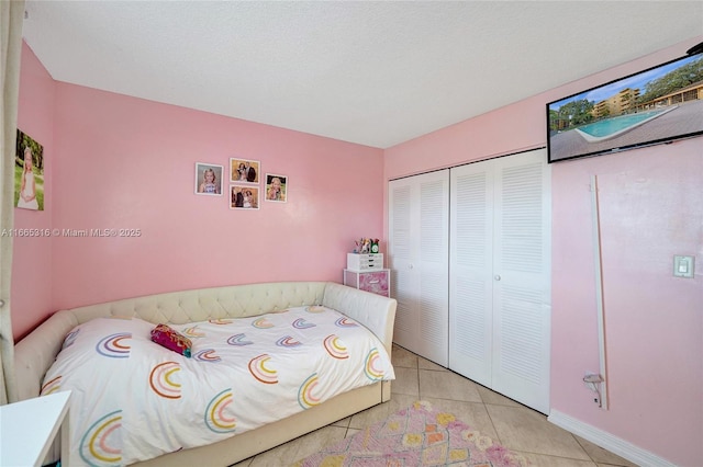 bedroom with light tile patterned floors and a closet