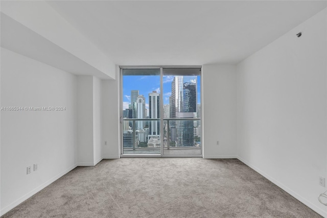 carpeted empty room featuring floor to ceiling windows