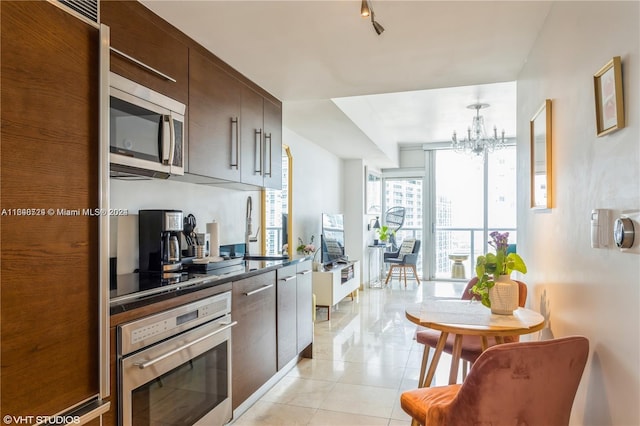 kitchen featuring dark brown cabinetry, a notable chandelier, appliances with stainless steel finishes, and sink