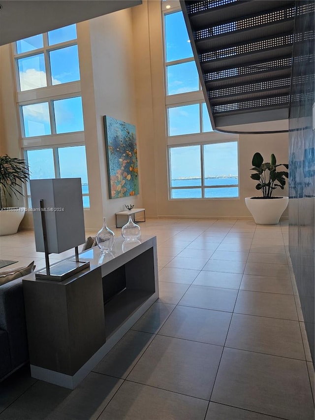 living room with a high ceiling, tile patterned floors, and plenty of natural light