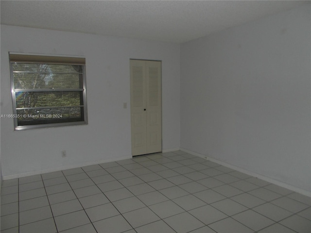 spare room featuring light tile patterned flooring