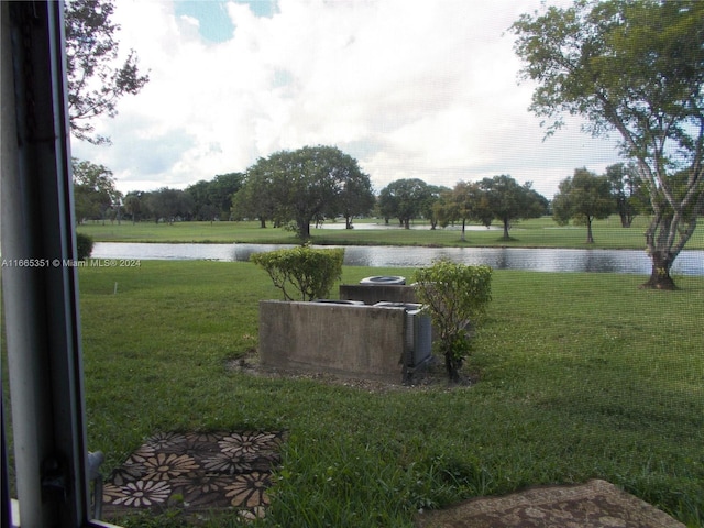 view of yard with a water view and central AC