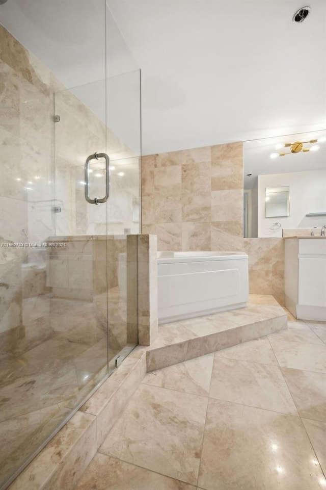 bathroom featuring tile walls, vanity, and separate shower and tub